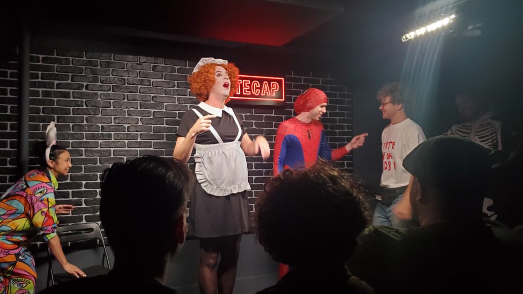 actors in halloween costumes making up an improv murder mystery