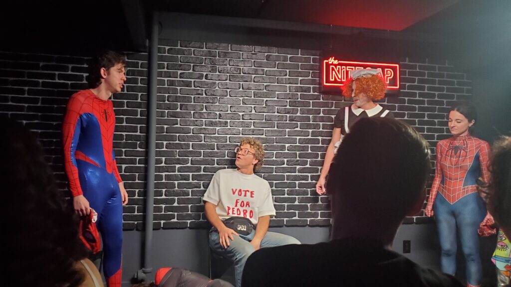 spider-man, napoleon dynamite, and maid costumes on the improv actors
