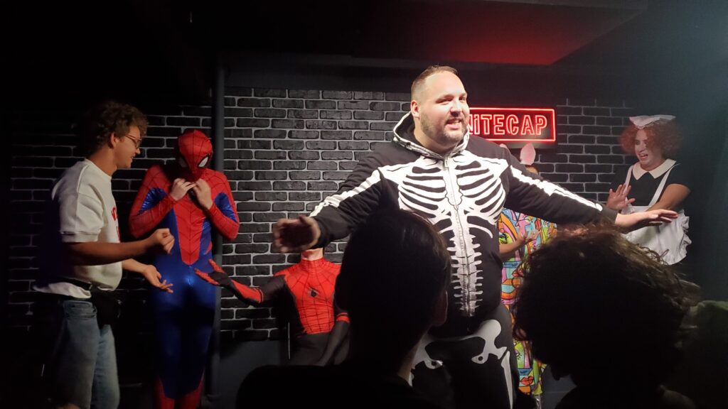 andy hendren in a skeleton costume in front of other actors