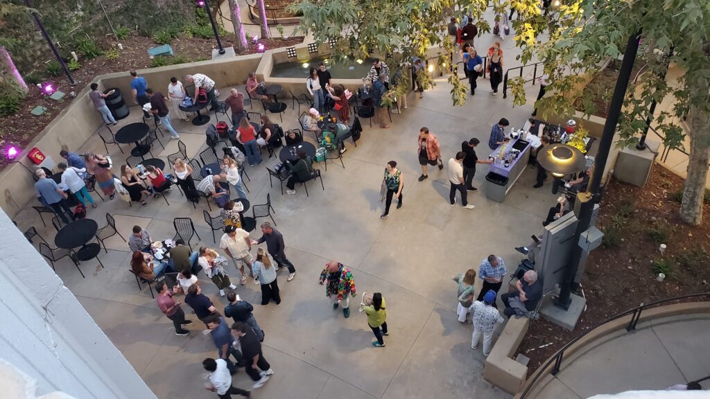 birds eye view from above of people walking below outside in the stone lobby courtyard area of the ford theater la