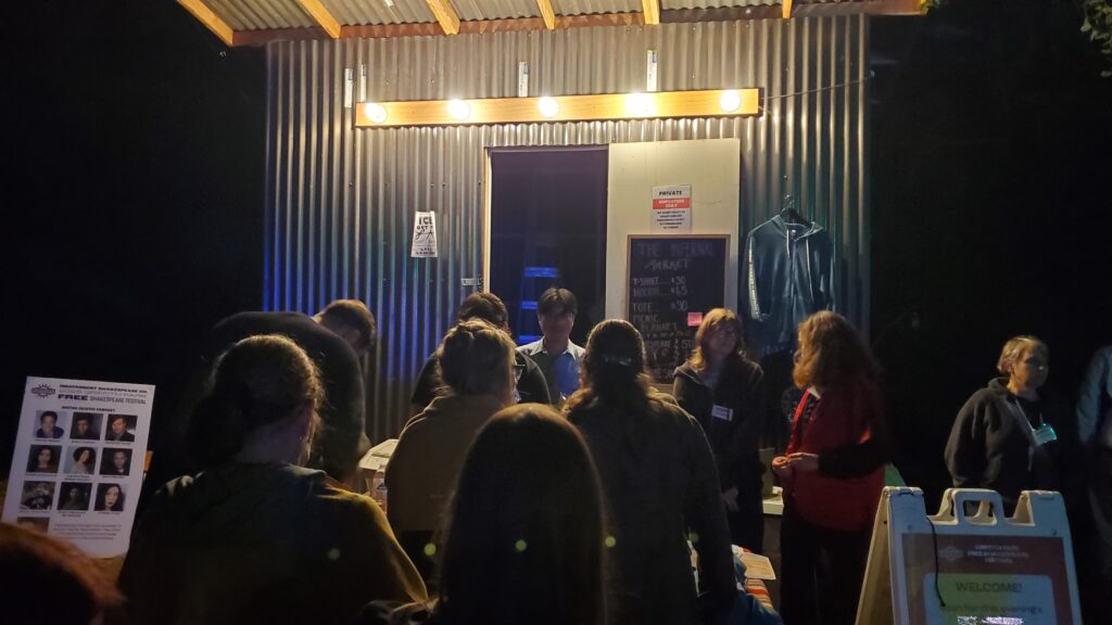 metal sided shack with a lot of people in front of it in line for cookies and shirts and merch