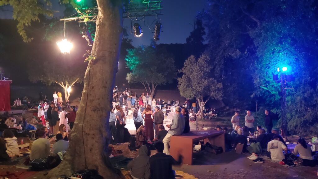 nighttime, people milling about the stage