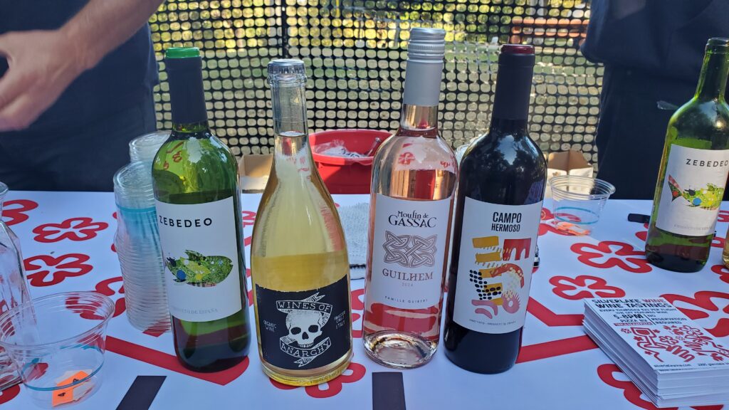 four colorful wine bottles on a table next to silverlake wine fliers