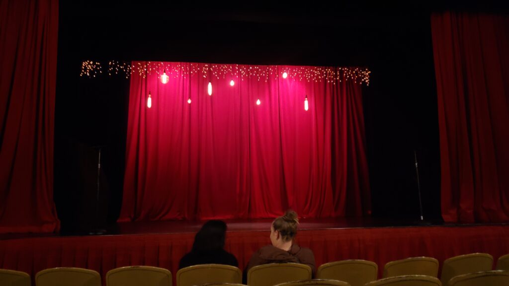 red curtains on stage for the largo at the coronet improvisational shakespeare production of henry three-thousand
